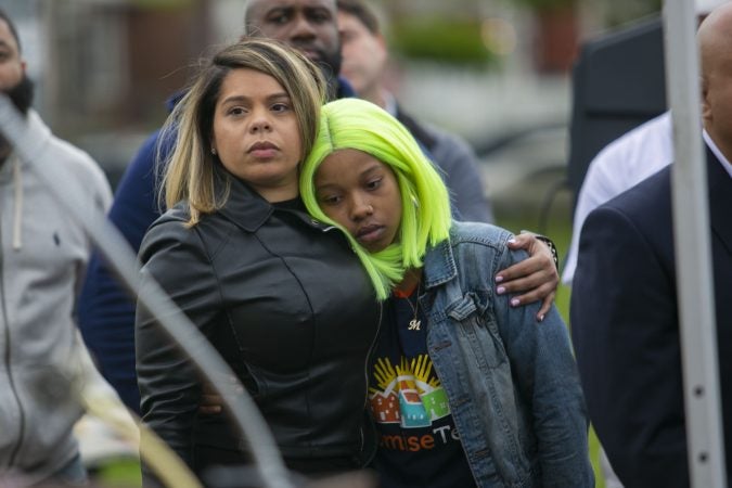 Julia Goodman lean on Janis Medina as they listen to the remark of speakers in a community rally held in Camden to create safer environment for children on Thursday, April 25, 2019. (Miguel Martinez for WHYY)