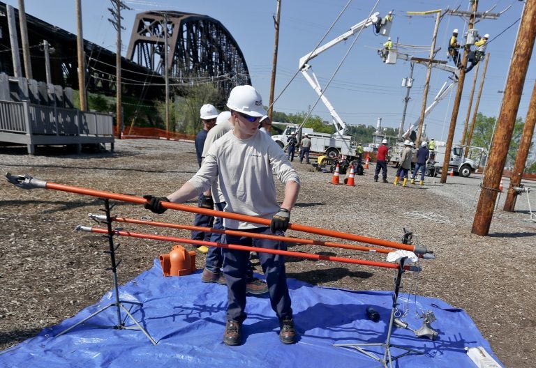 A student at the Duquesne Light Co. lineworker training center takes a high voltage hot stick to others learning the trade in Pittsburgh on Wednesday, May 9, 2018. They are taking part in a partnership training program with the Community College of Allegheny County. John Andzelik, the manager of workforce develpment for Duquesne light, said that people in the program range from recent high school graduates to older people looking for a career change. (AP Photo/Keith Srakocic)
