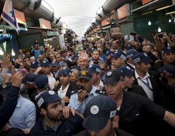 In this Tuesday, April 2, 2019 file photo, Israeli Prime Minister and head of the Likud party Benjamin Netanyahu, center, is escorted by security guards during a visit to the Ha'tikva market in Tel Aviv. (Oded Balilt/AP Photo)