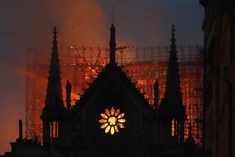 Flames and smoke rise from Notre Dame cathedral as it burns in Paris, Monday, April 15, 2019. Massive plumes of yellow brown smoke filled the air above Notre Dame Cathedral and ash fell on tourists and others around the island that marks the center of Paris. (Thibault Camus/AP Photo)