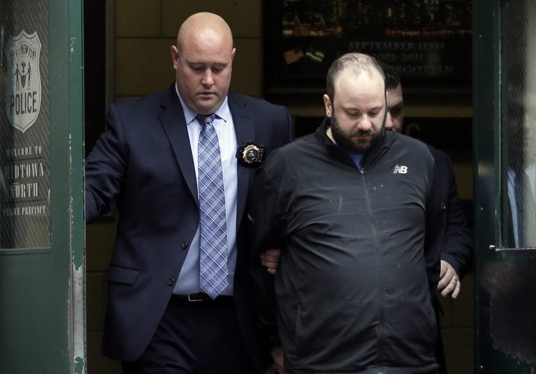Marc Lamparello, 37, (center), is escorted out of a police precinct in New York, Thursday, April 18, 2019.  Police say Lamparello was arrested after entering St. Patrick's Cathedral Wednesday night in New York with two cans of gasoline, lighter fluid and butane lighters. (Seth Wenig/AP Photo)