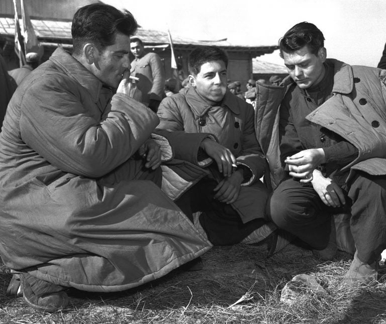 In this January 1954 file photo, three Americans who refused repatriation, take a smoke break outside the peace hut at Panmunjom, Korea. They were among 21 U.S. prisoners of war who refused to come home after the Korean War. The new PBS documentary 