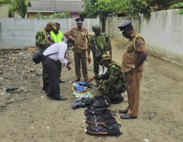 Sri Lankan police and army officers display gelatin sticks, detonators, back packs and other bomb making material recovered from the hide out of militants after Friday's gun battle in Kalmunai, in eastern Sri Lanka Sri Lanka, Saturday, April 27, 2019. Militants linked to Easter suicide bombings opened fire and set off explosives during a raid by Sri Lankan security forces on a house in the country's east, leaving behind 15 bodies, including six children. (Achala Upendra/AP Photo)