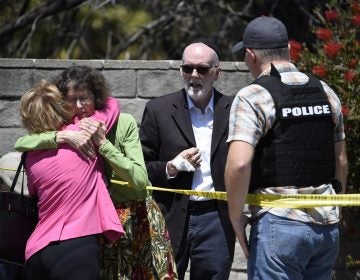 Two people hug as another talks to a San Diego County Sheriff's deputy outside of the Chabad of Poway Synagogue Saturday, April 27, 2019, in Poway, Calif. Several people have been shot and injured at a synagogue in San Diego, California, on Saturday, said San Diego County authorities. (Denis Poroy/AP Photo)