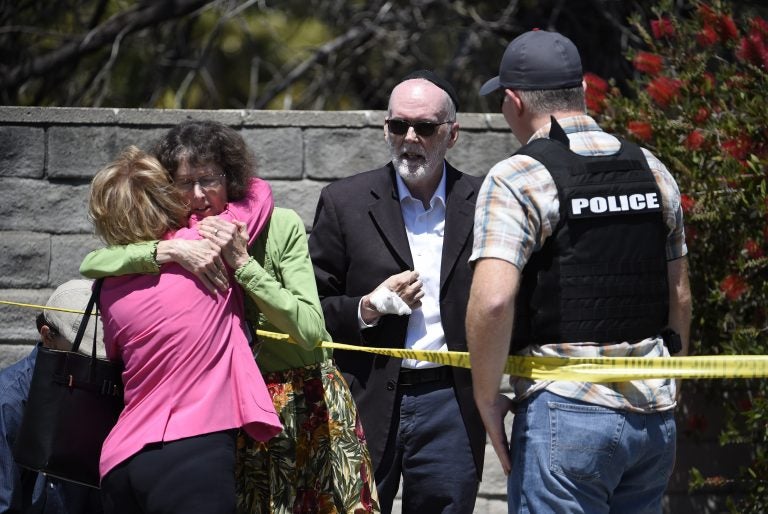 Two people hug as another talks to a San Diego County Sheriff's deputy outside of the Chabad of Poway Synagogue Saturday, April 27, 2019, in Poway, Calif. Several people have been shot and injured at a synagogue in San Diego, California, on Saturday, said San Diego County authorities. (Denis Poroy/AP Photo)