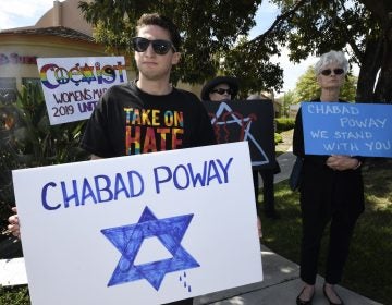 People gathering on a street corner hold signs in support of the victims of Saturday's shooting at Chabad of Poway synagogue, Sunday, April 28, 2019, in Poway, Calif. A man opened fire Saturday inside the synagogue near San Diego as worshippers celebrated the last day of a major Jewish holiday. (AP Photo/Denis Poroy)