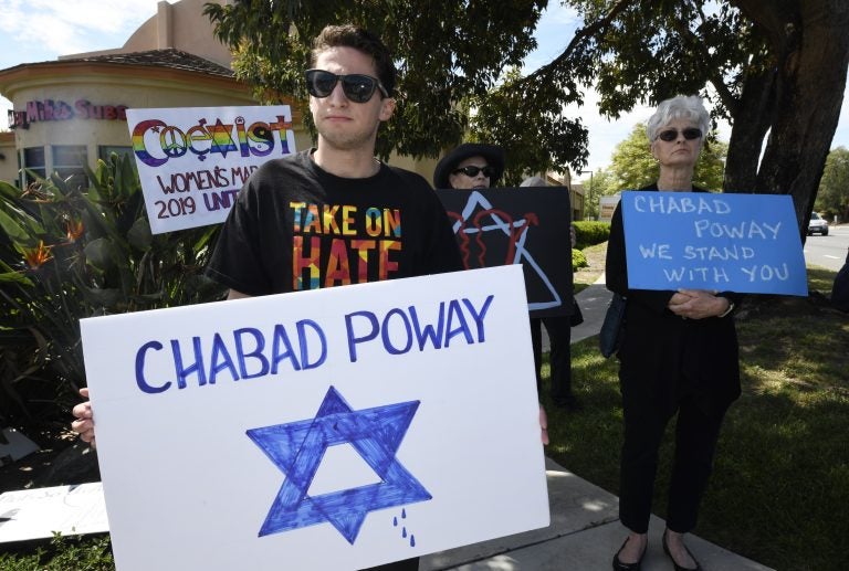 People gathering on a street corner hold signs in support of the victims of Saturday's shooting at Chabad of Poway synagogue, Sunday, April 28, 2019, in Poway, Calif. A man opened fire Saturday inside the synagogue near San Diego as worshippers celebrated the last day of a major Jewish holiday. (AP Photo/Denis Poroy)