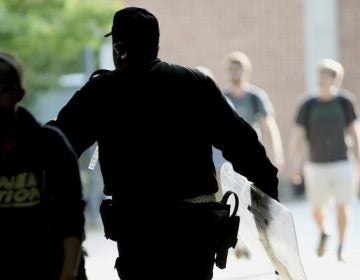 A University of North Carolina, Charlotte campus police officer carries a tactical shield after a shooting Tuesday afternoon, April 30, 2019, in Charlotte, N.C. The shooting on the campus left at least a few people dead and several wounded Tuesday, prompting a lockdown and chaotic scene in the state's largest city. (John Simmons/The Charlotte Observer via AP)