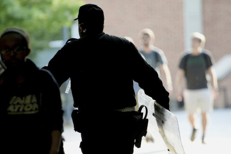 A University of North Carolina, Charlotte campus police officer carries a tactical shield after a shooting Tuesday afternoon, April 30, 2019, in Charlotte, N.C. The shooting on the campus left at least a few people dead and several wounded Tuesday, prompting a lockdown and chaotic scene in the state's largest city. (John Simmons/The Charlotte Observer via AP)