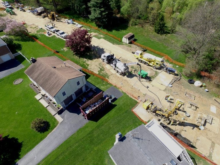 Mariner East 2 pipeline construction crews work in the backyards of homes on Lisa Drive in West Whiteland Township, Chester County, on May 2. Sinkholes that opened in the area prompted the state's Public Utility Commission to order that an existing pipeline nearby, the Mariner East 1, be shut down until it could be determined that the sinkholes didn't threaten its safety. PUC on May 3 approved a re-start of Mariner East 1. (Marie Cusick/StateImpact Pennsylvania)