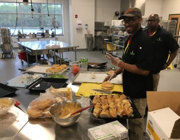 Food Bank workers prepare lunch inside the industrial kitchen at the new facility in Glasgow. The kitchen will be used for training in the expanded culinary program. (Mark Eichmann/WHYY)