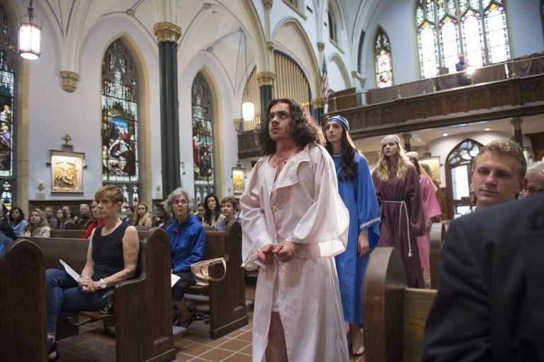  In the opening procession of “Via Crucis”, Jesus, portrayed by Marc Newsome, Mary, portrayed by Melanie Ashe, an the Weeping Women played by Miranda Pilate and Megan Short walk down the center aisle of St. John the Evangelist Church.   (Jonathan Wilson for WHYY)