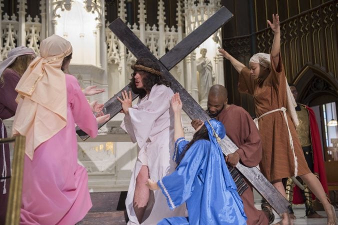 As Jesus falls, Mary and the Weeping Women cry out while Simon, portrayed by Langston Massey-Jefferson, helps to carry the cross. (Jonathan Wilson for WHYY)