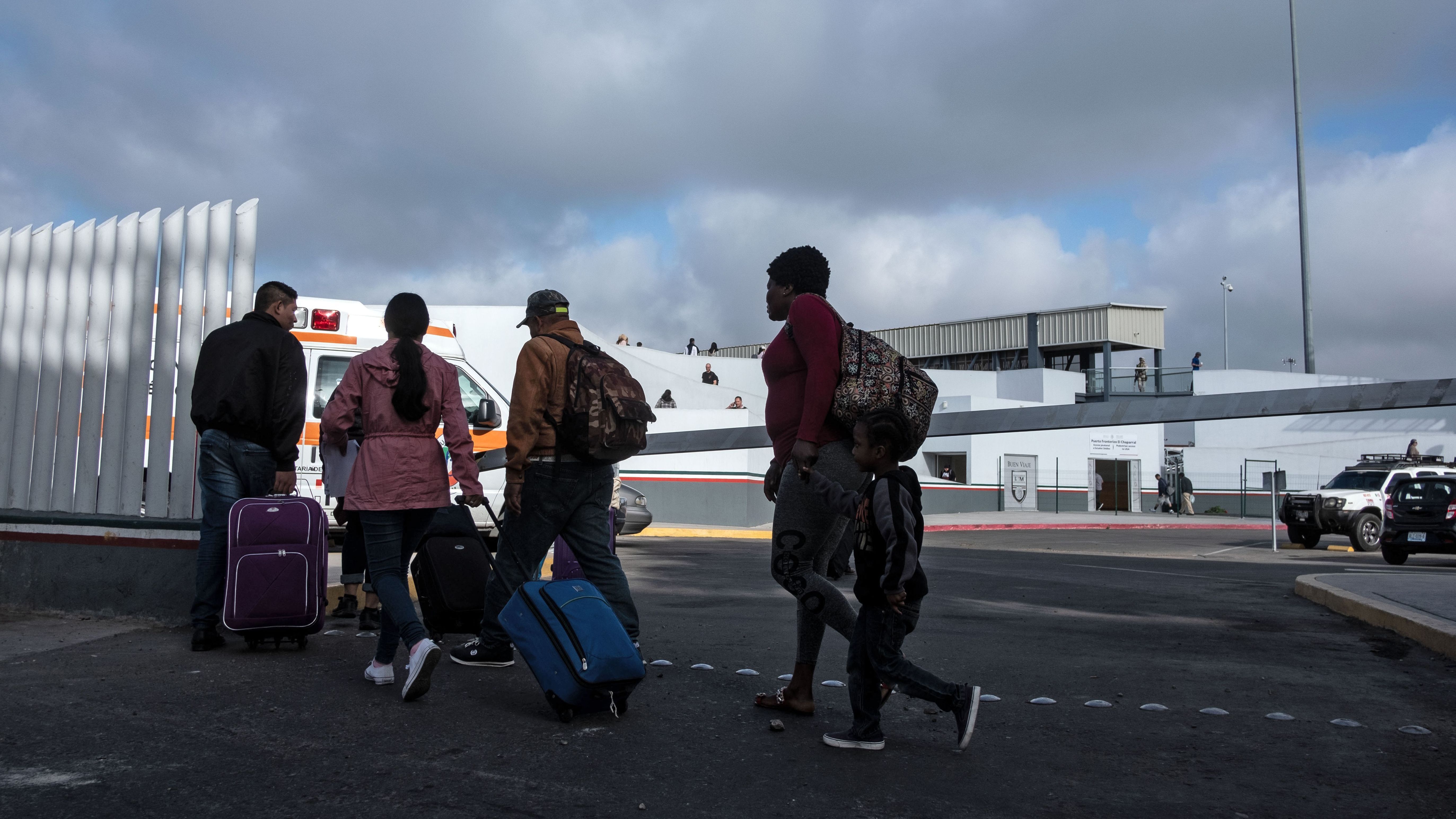 Asylum-seekers walk at El Chaparral Port of Entry to present themselves to U.S. border authorities to request asylum, in Tijuana, Baja California state, Mexico, on Tuesday.