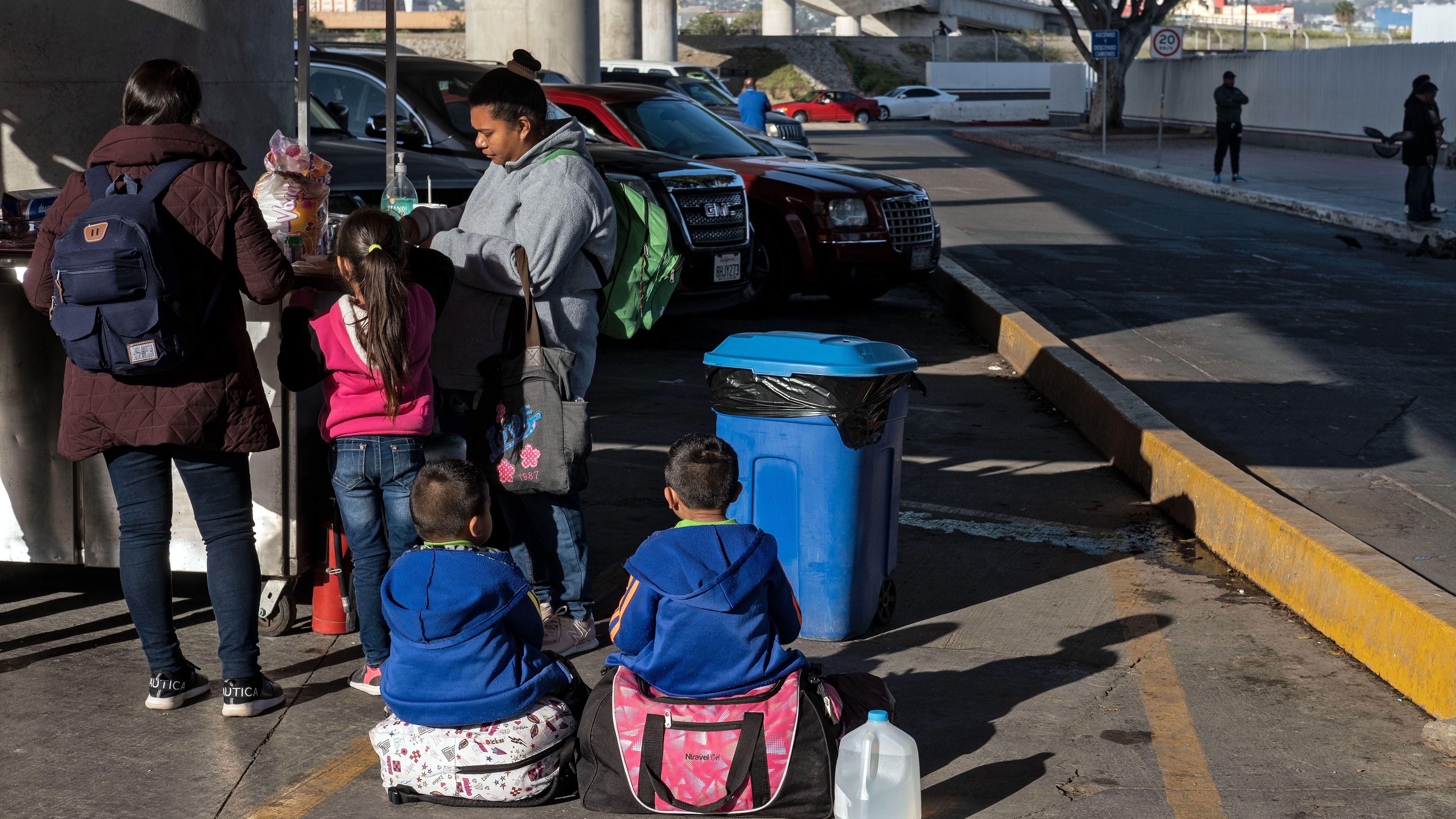 Asylum-seekers eat outside El Chaparral Port of Entry as they wait for to present themselves to U.S. border authorities to request asylum, in Tijuana, Baja California state, Mexico, on Tuesday.
