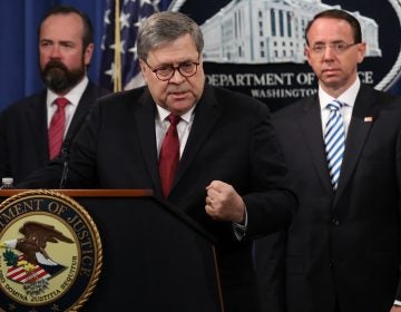 Attorney General William Barr speaks about the release of the redacted version of the Mueller report as U.S. Deputy Attorney General Rod Rosenstein (right) and U.S. Acting Principal Associate Deputy Attorney General Ed O'Callaghan listen at the Department of Justice Thursday in Washington, D.C. (Win McNamee/Getty Images)