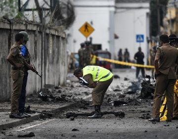 Sri Lankan security personnel inspect the debris of a van after it explodes on Monday near St. Anthony's Shrine in Colombo. Nearly 300 people died and more than 500 others were wounded after Sunday's attacks on churches and hotels. (Jewel Samad/AFP/Getty Images)