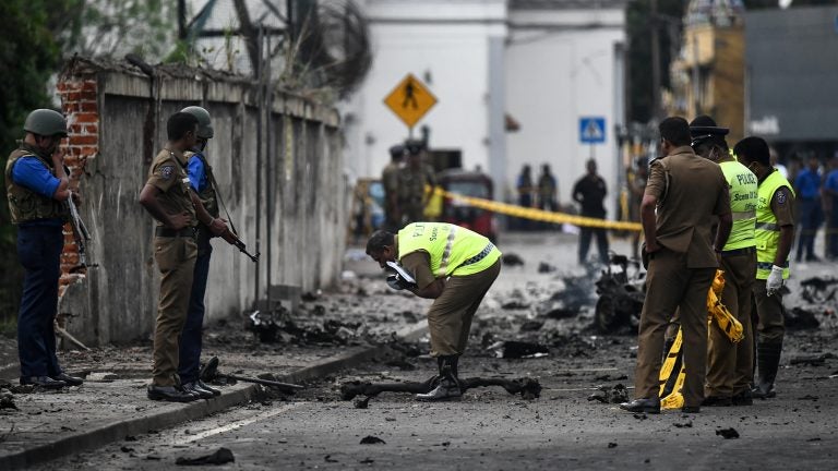 Sri Lankan security personnel inspect the debris of a van after it explodes on Monday near St. Anthony's Shrine in Colombo. Nearly 300 people died and more than 500 others were wounded after Sunday's attacks on churches and hotels. (Jewel Samad/AFP/Getty Images)