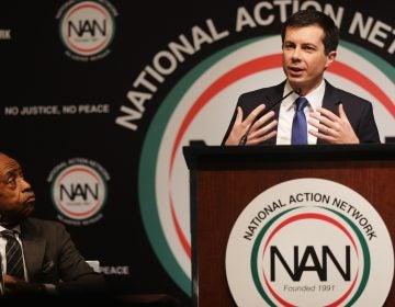 With the Rev. Al Sharpton looking on, Democratic presidential hopeful South Bend, Ind., Mayor Pete Buttigieg speaks at the National Action Network's annual convention Friday in New York City. (Spencer Platt/Getty Images)