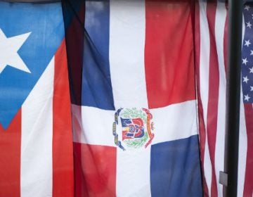 The flags of Puerto Rico, Dominican Republic and the United States hang in the window of the Latino Hispanic American Community Center in Harrisburg. (Tom Downing/WITF)