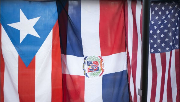 The flags of Puerto Rico, Dominican Republic and the United States hang in the window of the Latino Hispanic American Community Center in Harrisburg. (Tom Downing/WITF)