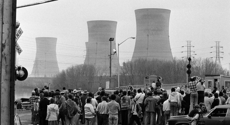 Newsmen and spectators stand in front of the main gate of the Three Mile Island Nuclear Generating Station in Middletown, Penn., April 2, 1979. (Jack Kanthal/The Associated Press)