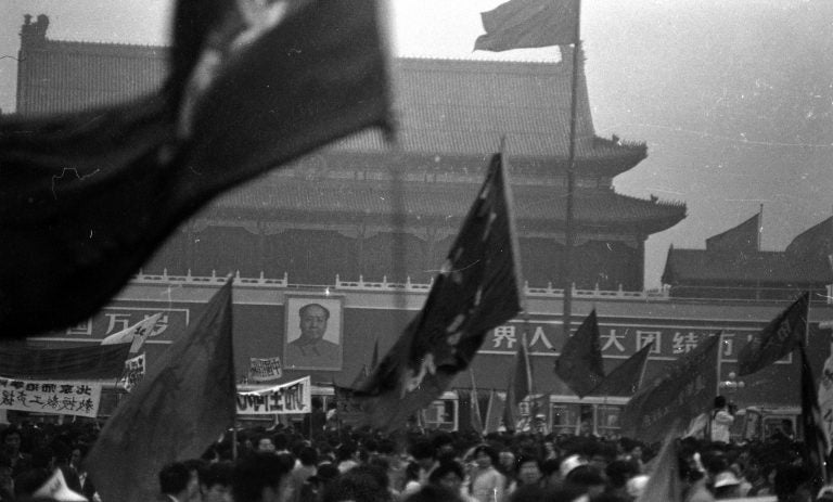 Protesters wave flags on Beijing's Tiananmen Square in the weeks leading up to the violent crackdowns on June 4. These photos were donated to Humanitarian China by the photographer, Jian Liu, then one of the student protesters. (Jian Liu/Humanitarian China)