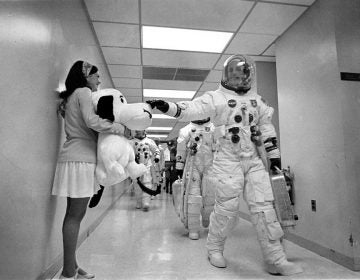 As the Apollo 10 crew walks along a corridor on the way to Launch Complex 39B, mission commander Thomas P. Stafford pats the nose of Snoopy, the mission's mascot, held by Jamye Flowers, astronaut Gordon Coopers' secretary. (NASA)