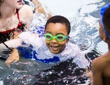 Natalie Edman (left), a freshman at the University of Pennsylvania, gives Quintin Whitner, 6 (center), a swimming lesson through We Can Swim on March 23, 2019. (Rachel Wisniewski for WHYY)