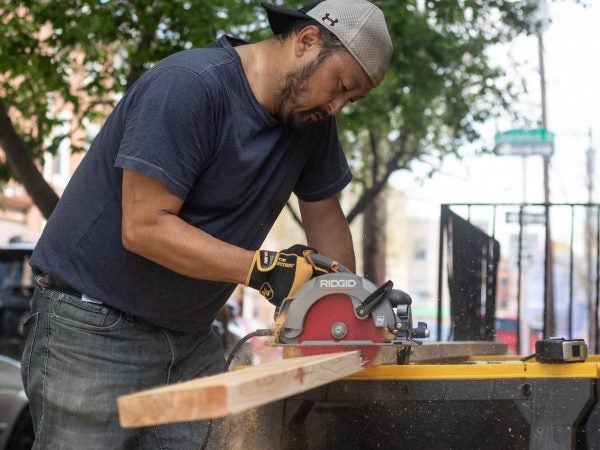 Kevin Lally cuts lumber for custom-sized garden beds. (Angela Gervasi for WHYY)