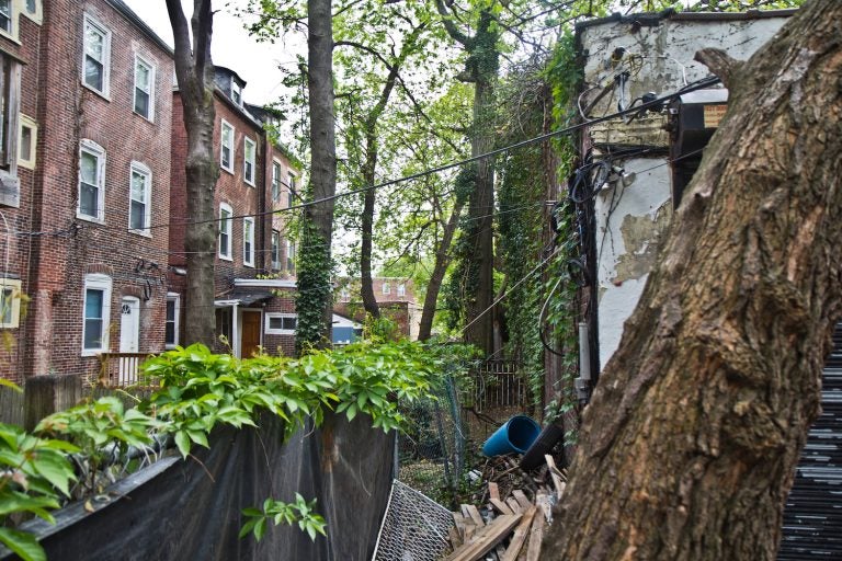 A former garage located behind homes on 51st Street is slated for redevelopment into an apartment building. (Kimberly Paynter/WHYY)