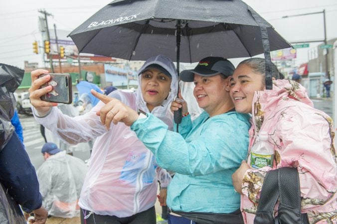 Carmen Hernandez, left, takes a selfie with Lissette Murria and Epi Estremera prior to the Broad Street Run. The women are members of the running group Latinas in Motion. (Jonathan Wilson For WHYY)