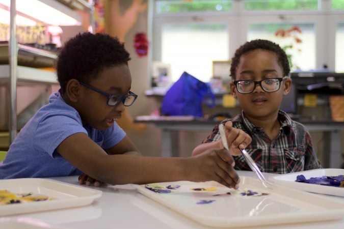 Pre-schoolers Sean and Ari prepare pressed flowers for cards at the classroom of the new horticulture center for students who are blind, visually impaired or have other disabilities at the Overbrook School of the Blind, on Tuesday. (Bastiaan Slabbers for WHYY)