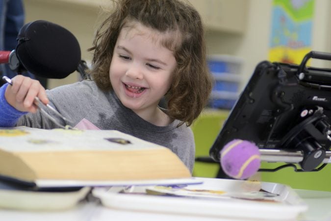 Pre-schooler Maddison prepares pressed flowers for cards at the classroom of the new horticulture center for students who are blind, visually impaired or have other disabilities at the Overbrook School of the Blind, on Tuesday. (Bastiaan Slabbers for WHYY)