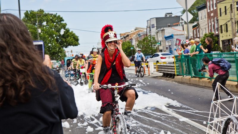 A cyclist rides through the soap pit at Johnny Brenda’s during the 2019 Kensington Kinetic Sculpture Derby. (Kimberly Paynter/WHYY)