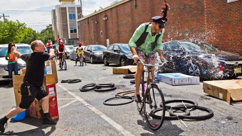 Riders get pelted with water balloons at Transport Cycles on the route of the Kensington Kinetic Sculpture Derby. (Kimberly Paynter/WHYY)