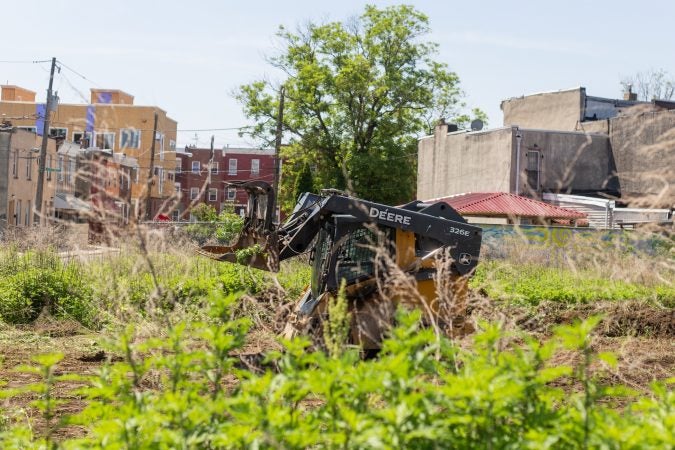 Anthony Patrick clears a plot of land near the César Andreu Iglesias Community Garden near Lawrence and Norris streets. (Angela Gervasi for WHYY)