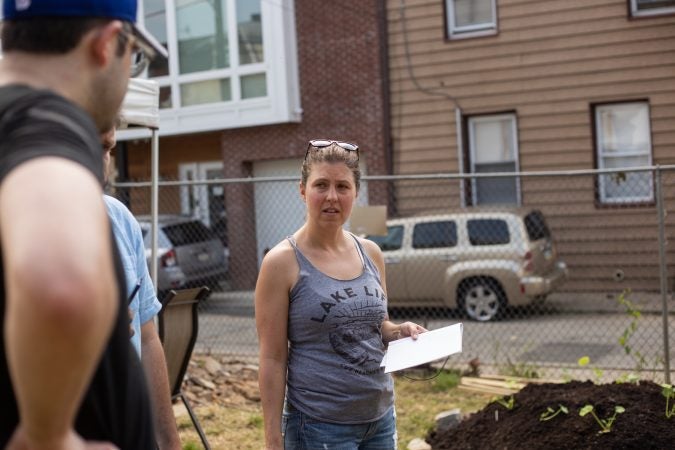 Jessica Noon speaks with volunteers to establish a watering schedule at the new Garden Esquina. (Angela Gervasi for WHYY)