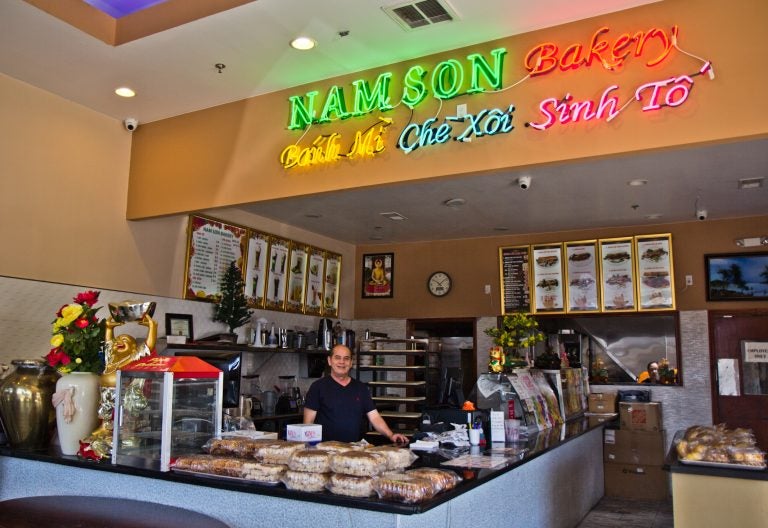 The owner of Nam Son Bakery behind the counter of the South Philadelphia shop. (Kimberly Paynter/WHYY)