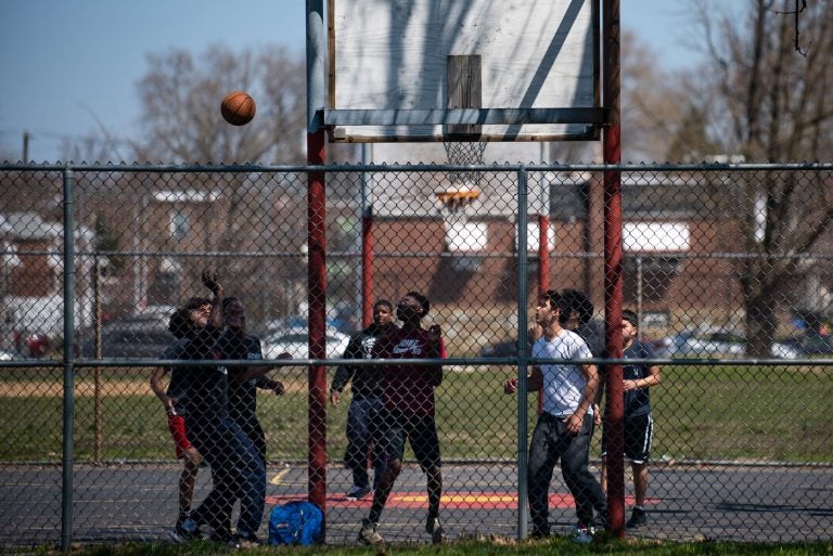 A group of boys play a game of basketball at Vogt park in Mayfair on Saturday, April 6, 2019. (Kriston Jae Bethel for WHYY)