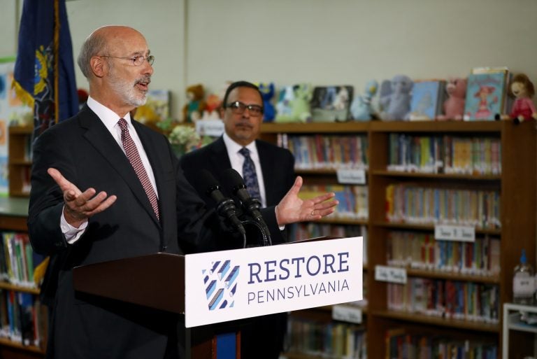 Pennsylvania Gov. Tom Wolf, left, speaks as John H. Taggart School Principal Nelson R. Reyes looks on during a news conference at the school's library, Thursday, March 21, 2019, in Philadelphia. Wolf discussed his infrastructure package, Restore Pennsylvania, to help remediate contaminants from Pennsylvania schools. (Matt Slocum/AP Photo)