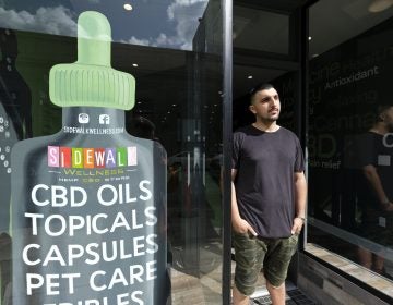 In this photo taken Thursday, March 21, 2019, Gus Dabais stands outside his Sidewalk Wellness store in San Francisco. CBD oil-infused food, drinks and dietary supplements are popular even though the U.S. government says they're illegal and some local authorities have forced retailers to pull products. The confusion has California, Texas and other states moving to legalize the cannabis compound that many see as beneficial to their health. (Eric Risberg/AP Photo)