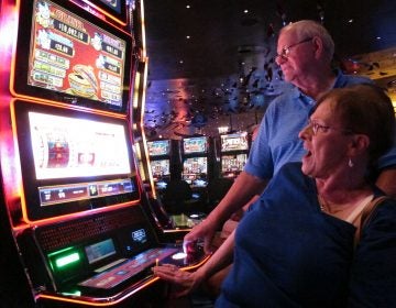 In this June 25, 2018 photo, Joyce Green of Vineland, N.J. reacts to a winning spin at a slot machine as her husband Tom looks on inside the Ocean Casino Resort in Atlantic City, N.J. The casino formerly known as Revel will turn a profit in May after months of steep losses. (Wayne Parry/AP Photo)