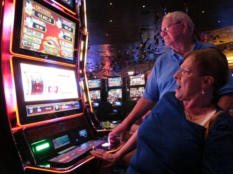 In this June 25, 2018 photo, Joyce Green of Vineland, N.J. reacts to a winning spin at a slot machine as her husband Tom looks on inside the Ocean Casino Resort in Atlantic City, N.J. The casino formerly known as Revel will turn a profit in May after months of steep losses. (Wayne Parry/AP Photo)