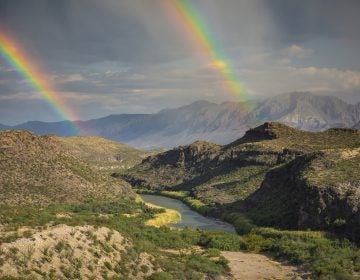 This December, 2017 photo released by Fin and Fur Films shows a double rainbow over Big Bend National Park, Texas, and the Rio Grande along the U.S.-Mexico border, with Mexico being on the right side of the river. The new documentary, 