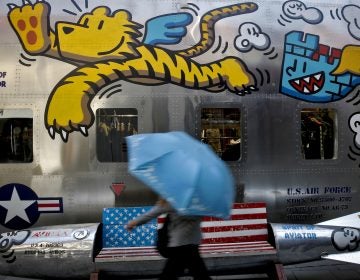 A woman walks by a bench painted with an American flag outside a fashion boutique selling U.S. brand clothing at the capital city's popular shopping mall in Beijing, Monday, May 13, 2019.  Companies waited Monday to see how China decides to retaliate for President Donald Trump’s latest tariff hike while forecasters warned their escalating fight over technology and trade might disrupt a Chinese economic recovery. (Andy Wong/AP Photo)