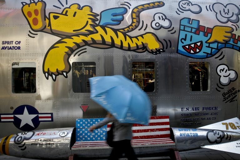 A woman walks by a bench painted with an American flag outside a fashion boutique selling U.S. brand clothing at the capital city's popular shopping mall in Beijing, Monday, May 13, 2019.  Companies waited Monday to see how China decides to retaliate for President Donald Trump’s latest tariff hike while forecasters warned their escalating fight over technology and trade might disrupt a Chinese economic recovery. (Andy Wong/AP Photo)