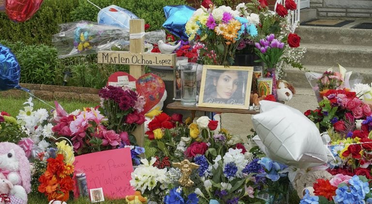 A memorial of flowers, balloons, a cross and photo of victim Marlen Ochoa-Lopez, are displayed on the lawn, Friday, May 17, 2019 in Chicago, outside the home where Ochoa-Lopez was murdered last month. Assistant State's Attorney James Murphy says a pregnant Ochoa-Lopez, who was killed and whose baby was cut from her womb, was strangled while being shown a photo album of the late son and brother of her attackers. (Teresa Crawford/AP Photo)