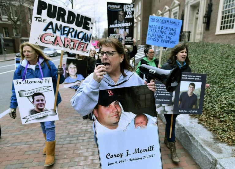 Global Opioids Italy Pain League In this Friday, April 12, 2019, file photo, Cheryl Juaire of Marlborough, Mass., (center), leads protesters near the Arthur M. Sackler Museum at Harvard University in Cambridge, Mass. Juaire, whose son was addicted to opioids and died of a heroin overdose in 2011, led the demonstration by parents who’ve lost children in the addiction epidemic. They want the Sackler family name removed from the building at Harvard. In New York, there’s a Sackler Wing at The Metropolitan Museum of Art and a Sackler Center for Arts Education at The Guggenheim. There’s a Sackler Room at the National Gallery in London, a Sackler Wing of Oriental Antiquities at the Louvre. (Josh Reynolds/AP Photo)