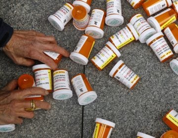 In this Friday, April 5, 2019, file photo, a protester gathers containers that look like OxyContin bottles at an anti-opioid demonstration in front of the U.S. Department of Health and Human Services headquarters in Washington, D.C. (Patrick Semansky/AP Photo)